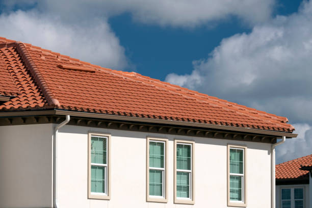 Overlapping rows of yellow ceramic roofing tiles covering residential building roof in southern Florida Overlapping rows of yellow ceramic roofing tiles covering residential building roof in southern Florida. red brick tile stock pictures, royalty-free photos & images