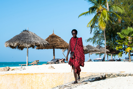 Zanzibar, Tanzania - January 02,2022: The Maasai warriors dressed in traditional clothes on sand beach of Zanzibar island.