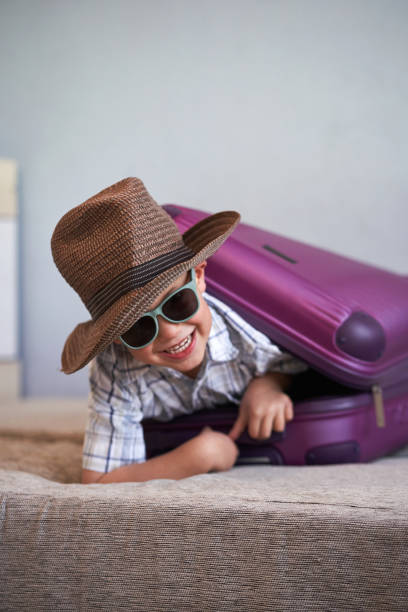 istock Ready to go! A child inside a suitcase ready for holidays. Selective focus. 1917087868