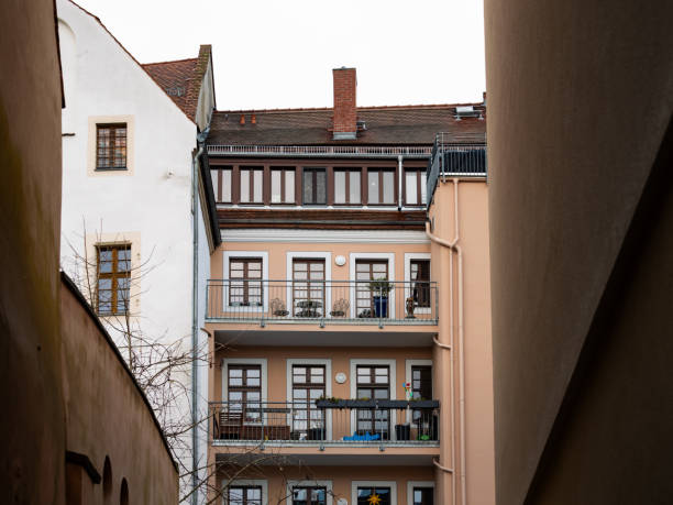 Residential building with balconies in between other houses. Apartments in good condition in a restored house. Gentrification in a town in Germany.
