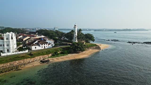 Aerial view of Galle Fort, coastal fortress, landmarks, lighthouse, and Indian Ocean waves on Sri Lanka coastline. Historical architecture, tourism attraction with tropical nature, heritage site.