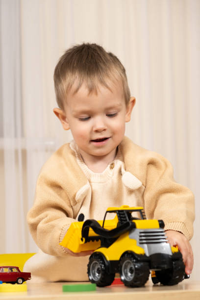 istock Little cute boy playing with toys while sitting at table 1917154398