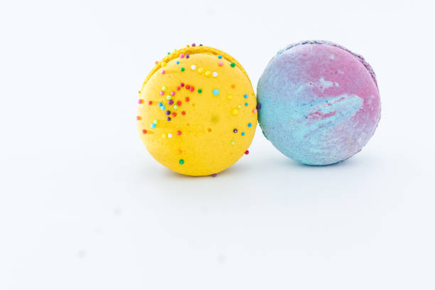 istock Sweet colorful macarons isolated on white background. Tasty colorful macaroons. Two multi-colored blue and yellow macaroons. French pastry made from egg whites. 1917155444