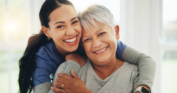 happy woman, nurse and hug senior patient in elderly care, support or trust at old age home. portrait of mature female person, doctor or medical caregiver hugging with smile for embrace at house - ouderenzorg stockfoto's en -beelden