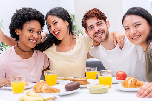 Close-knit friends from Afro American, Hispanic, and Asian backgrounds enjoy a vibrant breakfast.