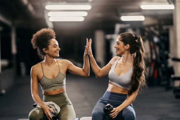 istock Fit friends in shape giving high five for progress while sitting in a gym. 1917188329