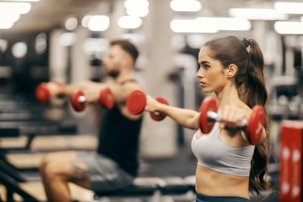 istock A strong sportswoman is doing exercises with dumbbells in a gym while sitting on a bench. 1917189418