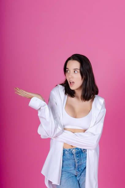 istock Surprised Woman Gesturing No Understanding on Pink 1917198176