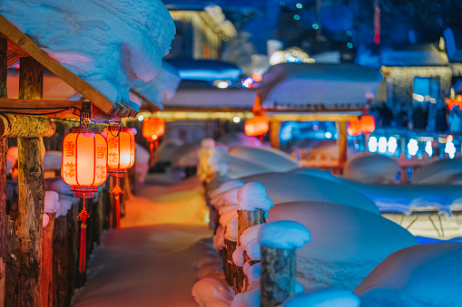 Winter Season Snow Town Xuexiang with chinese lantern deep snow at night Colorful lighting on Snow-Covered houses