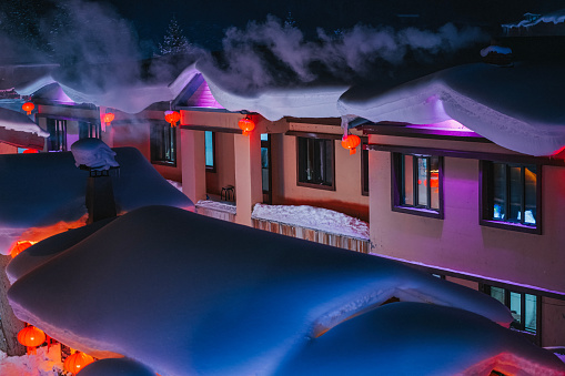 Winter Season Snow Town Xuexiang with chinese lantern deep snow at night Colorful lighting on Snow-Covered row houses