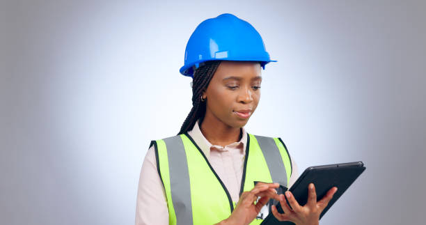 istock Black woman, engineer and typing on tablet in studio isolated on white background mockup space. Technology, architect and research on internet, digital app or planning construction for communication 1917285888