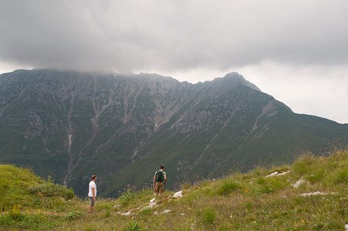 Two Hikers Stop to Look at the Panorama on Mount Arera. Oltre il Colle, Bergamo Province, Italian Alps