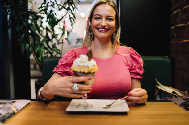 istock Smiling woman eating dessert at a bakery table 1917334308