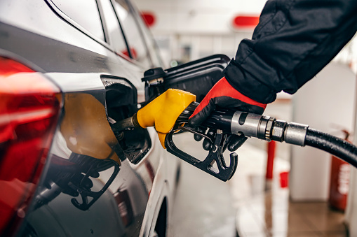 Cropped picture of a hand filling up car tank on gas station.