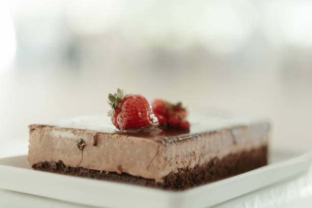 istock two strawberries on top of a chocolate cake with icing 1917345553