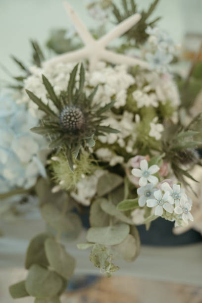 there is a vase with flowers and leaves in it on the table