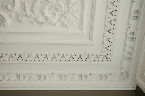 This is an elegant ceiling featuring a white painted finish and a round clock in the center