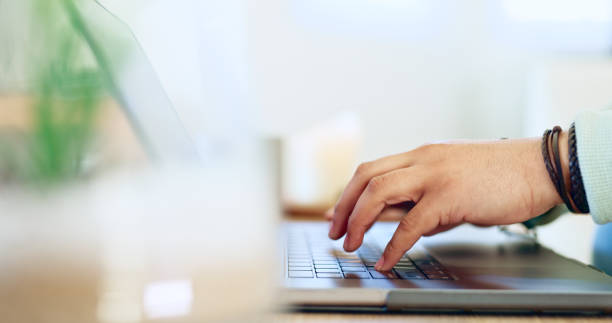 istock Hands, typing and man with remote work on laptop, desk and closeup on workplace in home. Computer, keyboard and person writing SEO, copywriting or working online with email marketing on the internet 1917354748