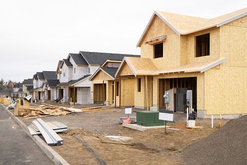 A line of  new home construction showing progression of finished to nearly completed