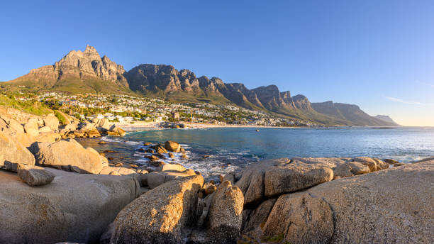 Panorama of Camps Bay with the mountain range the 12 Apostles Panorama with evening mood on the beach of Camps Bay, in background the 12 Apostles, near Cape Town in South Africa twelve apostles south africa stock pictures, royalty-free photos & images