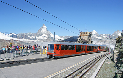 Train of the Gornergratbahn at the Gornergrat station at an altitude of over 3000 meters with a view of the iconic peak of the Matterhorn