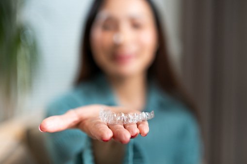 Happy woman with transparent dental aligners