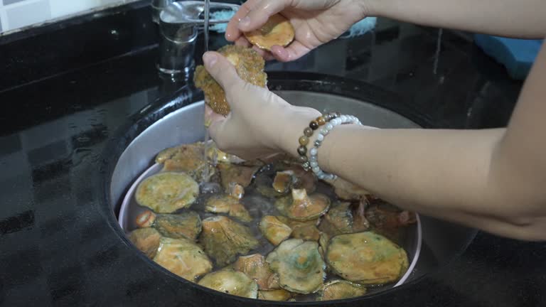 The women hand washes the Tricholomopsis rutilans mushrooms in the water