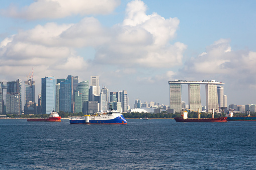 Singapore , Singapore - 11.24.2022: View from the sea to Singapore with high-rise buildings and the coast and transport ships at anchor.