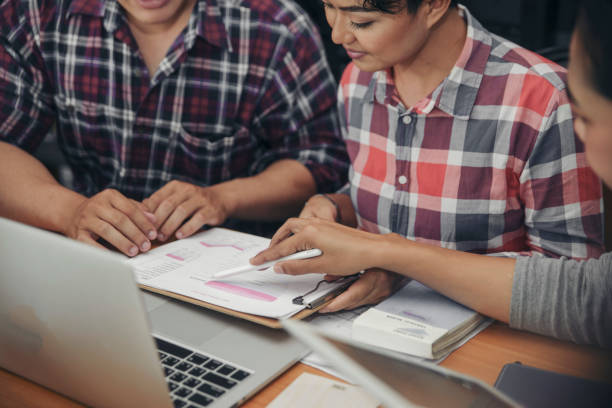 istock Group of Business people point to annual report and discussion to solution problem during brainstorming meeting. Collaborate between Professional Businessman and Partnership. Strategy Business concept 1917457145