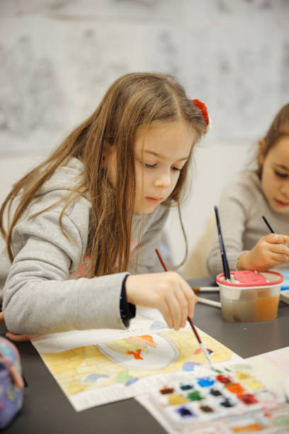 istock Sisters having fun with watercolor paints at school 1917493983