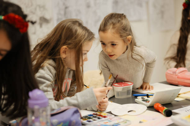 istock Sisters having fun with watercolor paints at school 1917499749