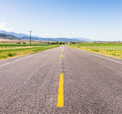 Empty asphalt road with trees on the side and blue sky background