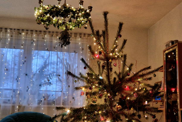 old historical eight-armed chandelier. silver single with spruce cone shaped bulbs and a ball at the bottom. white room with curtain. bottom view. candlestick shape, spider, wrapped, advent, chrome