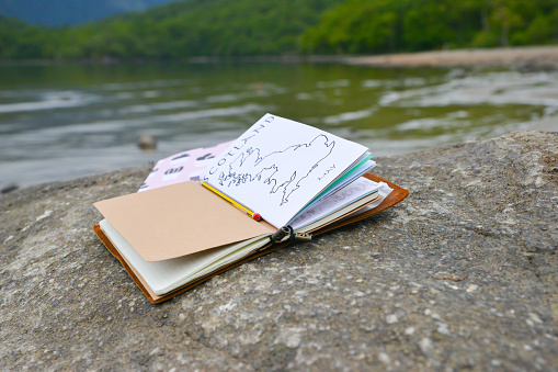Journaling , popular hobby , journal placed on rock by side of lake in Scotland a lovely spot to sit and write whilst enjoying nature and tranquility.