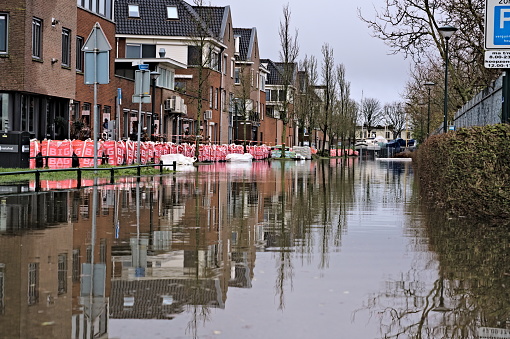 High water level from lake causes flooding in a Dutch city street after storm Henk. Big bags and sandbags protect houses and apartment building from water damage. Hoorn, Netherlands 01-05-2024. Horizontal photo.