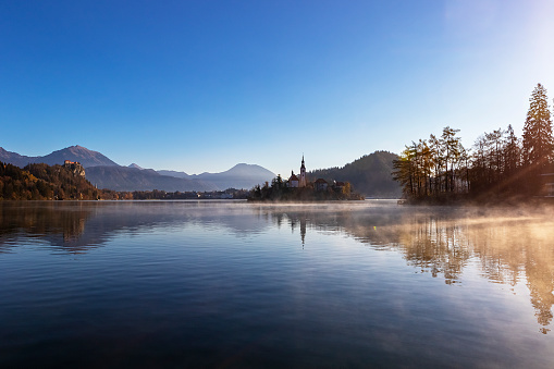 Bled lake in autumn morning, scenic view of Bled Island and Bled castle, mountains in the background