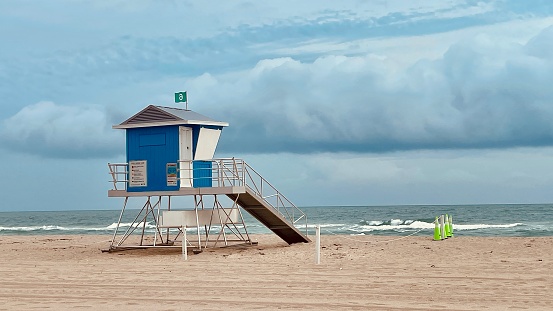 Summer scene with a typical Art Deco architecture style colorful lifeguard house in Miami Beach, Florida in the colors of the American flag with blue sky in the background.