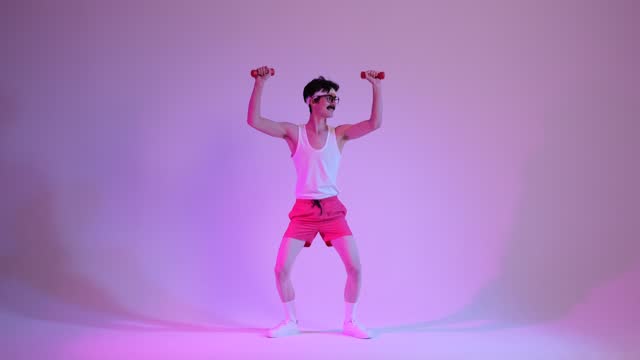 Positive 80s Man Squats with Dumbbells on Purple Background