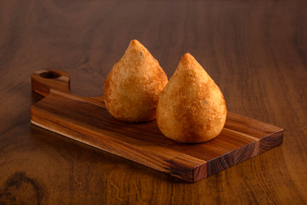 Coxinha on wooden cutting board. Typical Brazilian snack. Coxinha on wooden cutting board. Wooden background. coxinha stock pictures, royalty-free photos & images