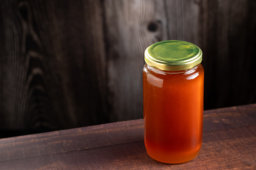 Glass jar of honey. Fresh honey in the jar.