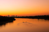 View of the Vistula River with a panorama of the capital city Warsaw during orange sunset.