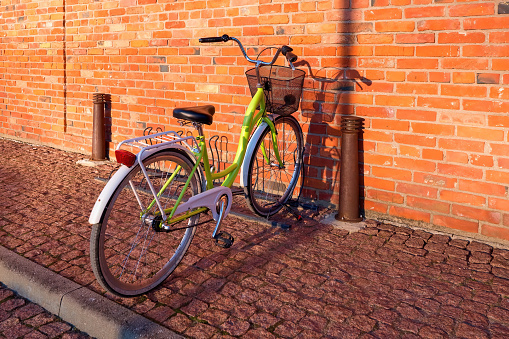 Bicycle near a red brick wall. Bicycle with wicker basket.