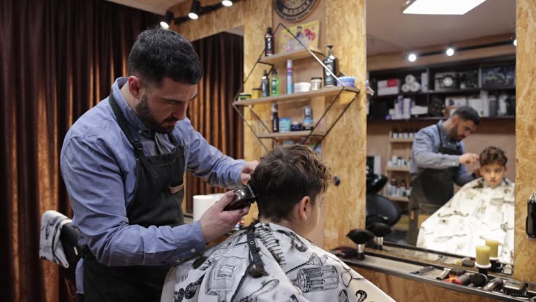 Caucasian boy getting an haircut, from the barber at the barber shop