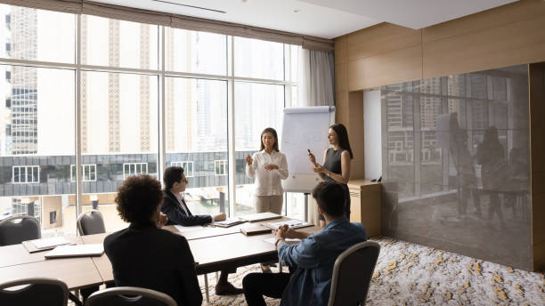 istock Two diverse speaker women presenting marketing report on whiteboard 1917761163
