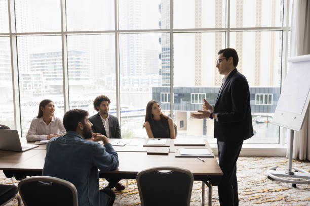 istock Confident young team leader man talking to multiethnic colleagues 1917763289