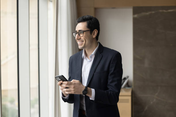 istock Cheerful young Arab entrepreneur man holding mobile phone 1917765397