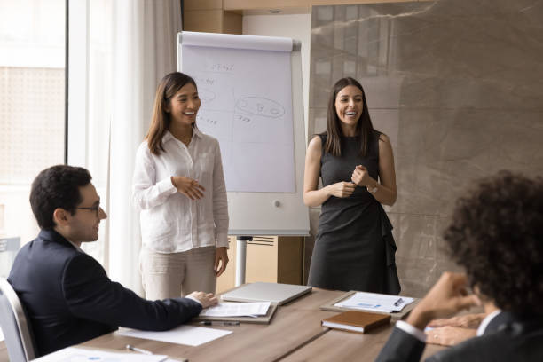 istock Two happy business coaches training employees, presenting project to team 1917789392
