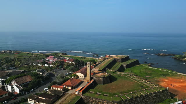 Aerial view of Galle, Sri Lanka, showcasing the historic fort, cricket stadium, coast and urban landscape with verdant tropical fauna, a blend of heritage and modernity.