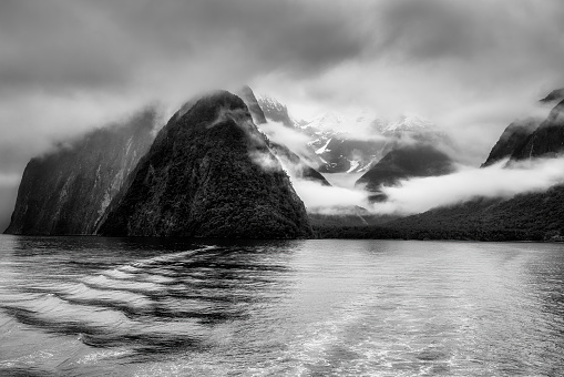 Black and white version of Mitre Peak in Milford sound in stormy rain cloud and mist