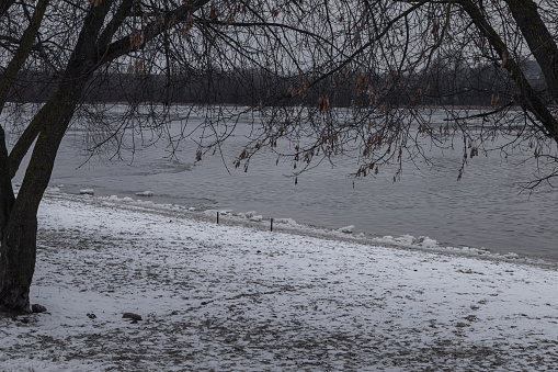 Kyiv, Ukraine - January 7, 2024 due to sub-zero temperature outside, frozen river and sand on the embankment.